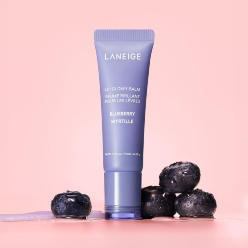 En lila Laneige läppbalsamtub märkta "Blueberry Myrtille" omgiven av blåbär på rosa bakgrund.