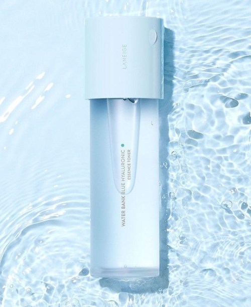En vit flaska märkt 'WATER BANK BLUE HYALURONIC ESSENCE TONER' flyter i klart vatten.