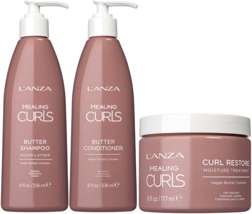 Tre rosa hårpleieflasker og en krukke merket 'Healing Curls' med smørbaserte produkter.
