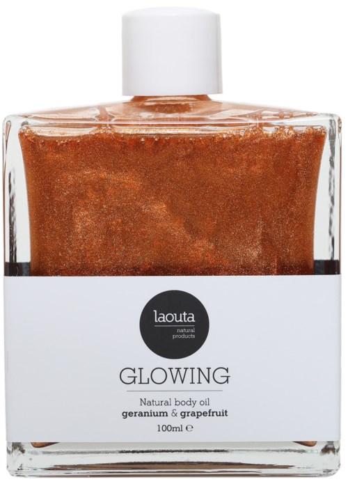 Lasipullo kehon öljylle, ruskea tekstuuri, etiketti 'Laouta Glowing' ja geranium sekä greipfruuromake.