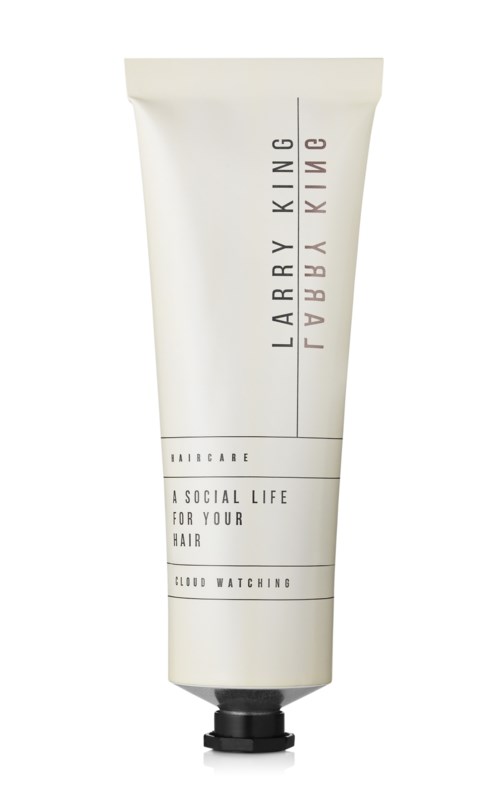 En vit tub med hårvårdsprodukt med svart lock, märkt 'Larry King' och 'A Social Life for Your Hair.'