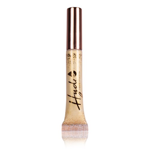 A tube of concealer with a metallic cap and beige liquid, labeled 'Huda'; used for makeup.