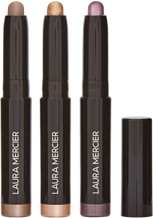 Tre Laura Mercier highlighterstift i beige, guld och rosa nyanser med svart lock.
