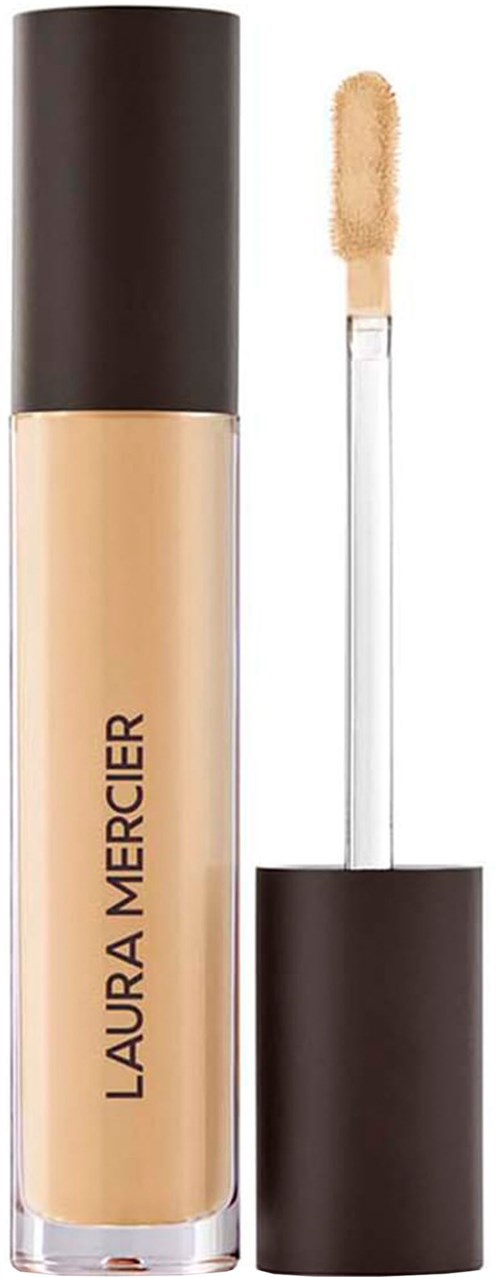 En beige flytande foundationflaska med svart lock och applikator.