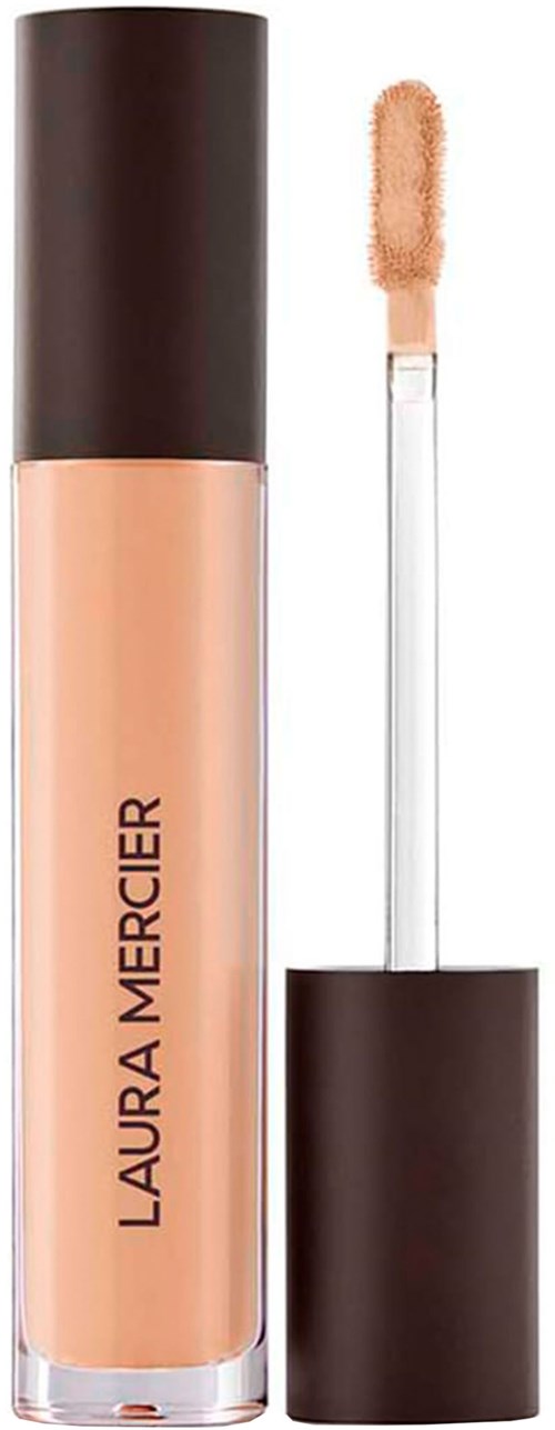 En Laura Mercier-blekningskräm med applikator och beige flytande i en genomskinlig flaska.