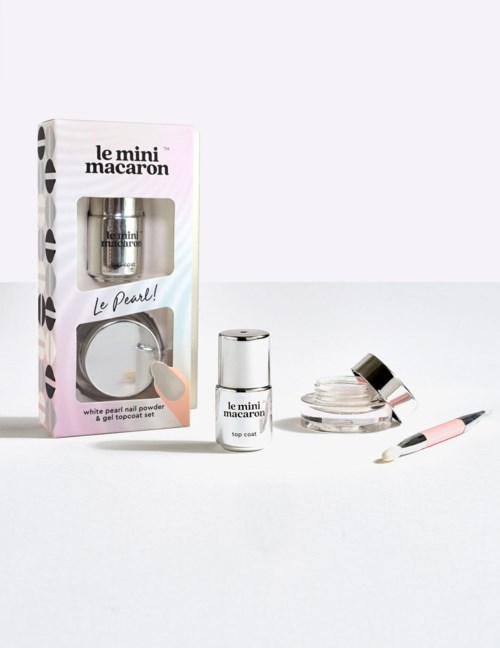 A skincare set includes a small bottle, a jar, and a tool, all branded 'le mini macarons,' displayed in front of a box.