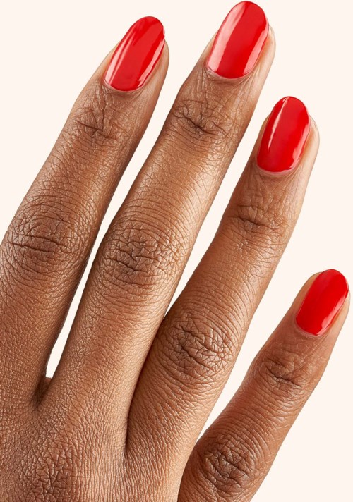 Hand med röda naglar, slät hud och naturlig textur.