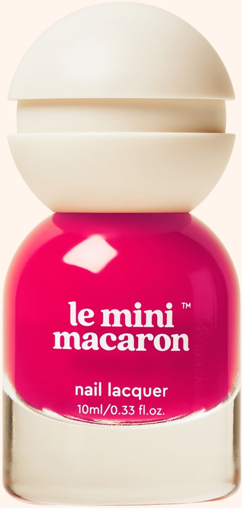 A small pink nail lacquer bottle with a white cap that looks like a macaron.