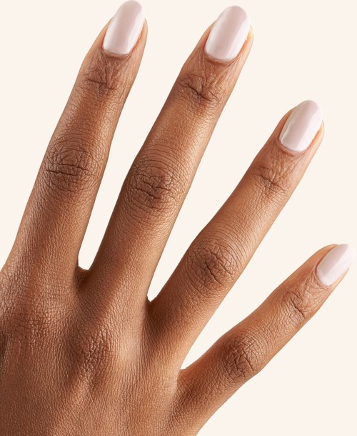 Close-up of a hand with well-manicured, pale pink nails, showing smooth skin and neatly trimmed cuticles.