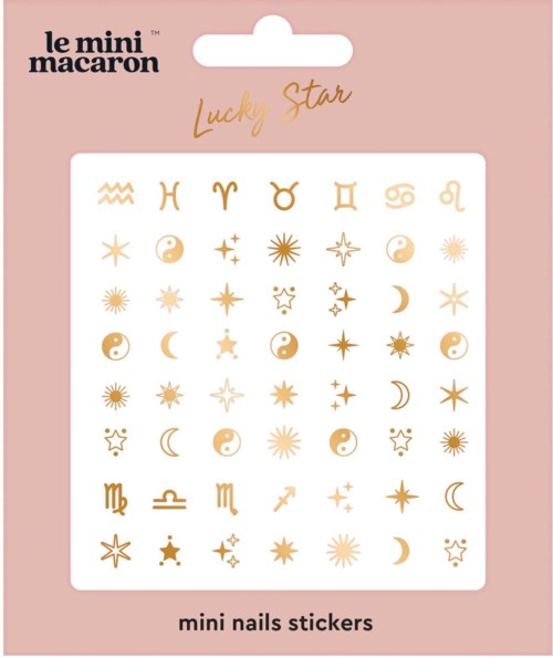 Ett set med små nagelklistermärken i guld med olika månar, stjärnor och zodiakssymboler på en rosa bakgrund.