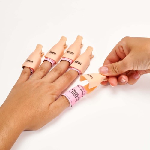 En hand gör fingerövningar med gummiband runt fingrarna och en person drar i ett band.