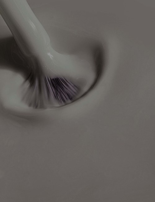 A close-up of a toothbrush brushing purple toothpaste on teeth.