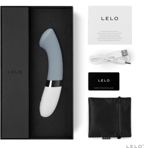 Ein beiges und weißes gekrümmtes Gerät, ein USB-Kabel, eine Garantiekarte, eine schwarze Registrierungs-Karte und eine schwarze Tasche in einer schwarzen Schachtel.