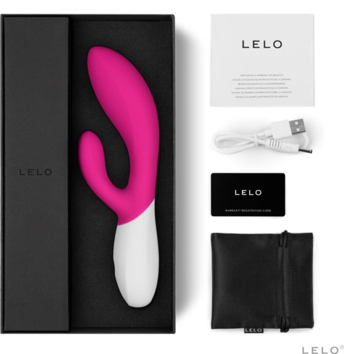 En rosa och vit böjd silikonleksak, en vit USB-laddare, ett svart garanti-kort och en svart väska i en låda.