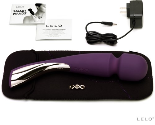 En personlig massager i lila och svart med laddkabel och instruktioner från LELO.