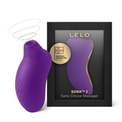 En lilla, buet enhet ved siden av en eske med en lilla form og gulldetaljer, merket som en Sonic Clitoral Massager.