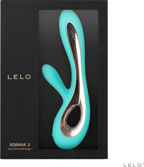 Ein türkisfarbener, gebogener Doppel-Aktions-Massager in einer schwarzen Box mit Beschriftung. Die Box hat eine Spinnenform und Text.
