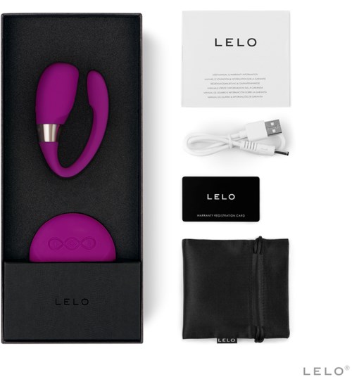 En lilla vibrator med kontrolknapper, et opladningskabel, et garantie-kort og en opbevaringspose i en æske.