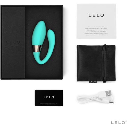 A teal-colored personal massager with a silver band, a black storage pouch, a user manual, warranty card, and a charging cable.