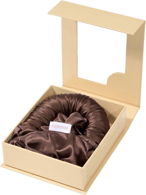Eine Schachtel mit Deckel, enthält ein braunes Satin-Produkt, wahrscheinlich ein Geschenk oder Kleidungszubehör.