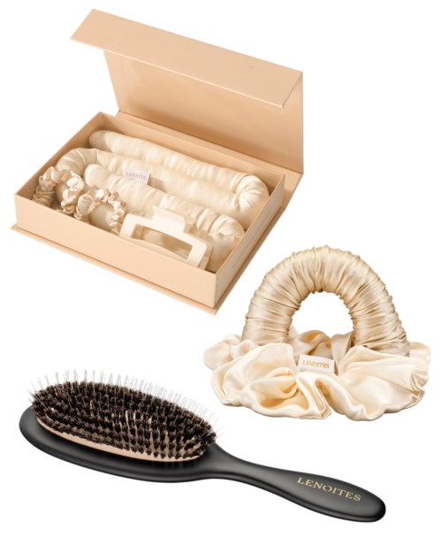 Eine Haarbürste, ein Satin-Haargummi und eine Schachtel mit Haarschmuck sind gezeigt.