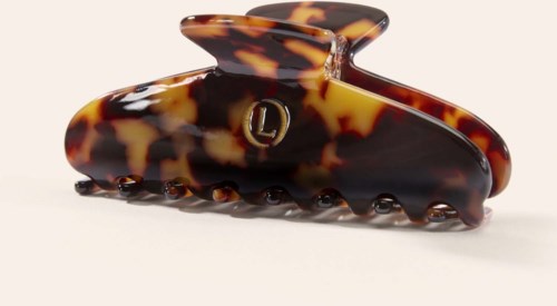 A large tortoise shell-patterned hair claw clip with a small metal 'L' emblem on the side.