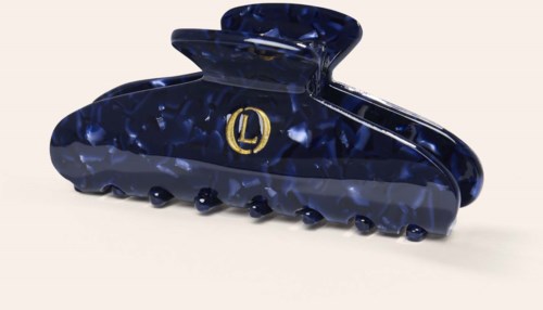 A dark blue hair claw with a gold logo in the middle, made of shiny, marbled plastic.