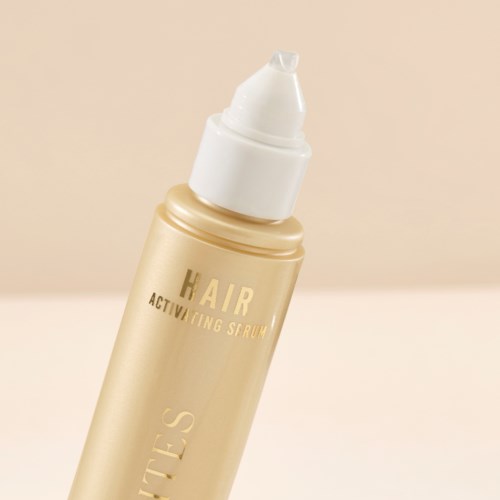 A gold-colored bottle labeled 'Hair Activating Serum' with a white pump top.