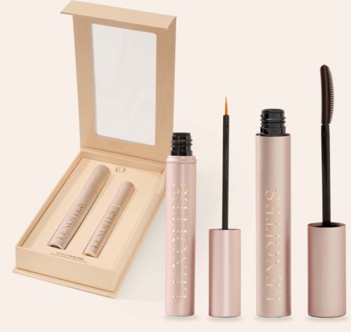Pinkfarbene Wimpernserum-Röhre und Mascara mit Bürsten in beiger Schachtel, mit Spiegel im Deckel.