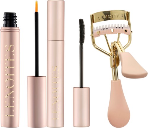 Ein Set Make-up-Produkte, einschließlich Mascara, Lippenstift, Mascara-Bürste und Wimpernzange in Rosa und Gold.