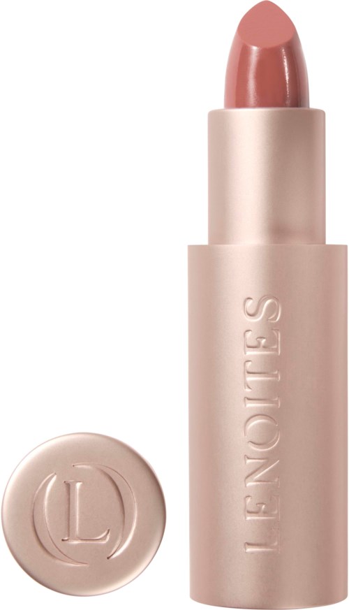En rosa-nude läppstift i ett ljust rosa rör med rund hatt med logga, står upprätt.