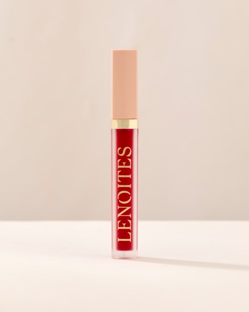 En leppestiftbeholder med beige hette og rød kropp med teksten "L'ENOTTES" skrevet på den.