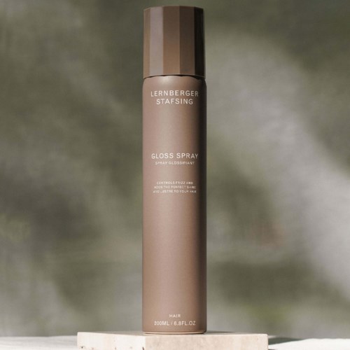 En lång, beige sprayflaska med brunt lock, märkt 'Lernberger Stafsing Gloss Spray' för hår.