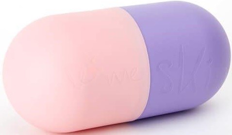 En stor kapselliknande tablett, halvpink och halvlila, med subtil text på ytan.