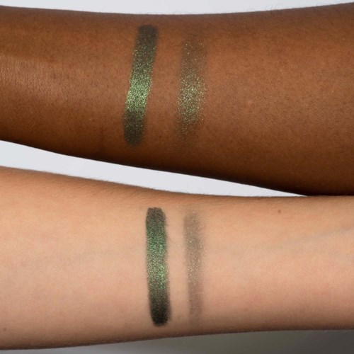 Two arms, one with darker skin, show green eyeshadows swatched, one with lighter skin, shows similar swatches.