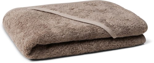 En brettet brun håndkle med en stripe, ser myk og fluffy ut, på hvit bakgrunn.
