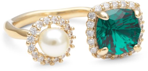 A gold ring with a large green gemstone, small diamonds, and a pearl, all decorated with gold accents.