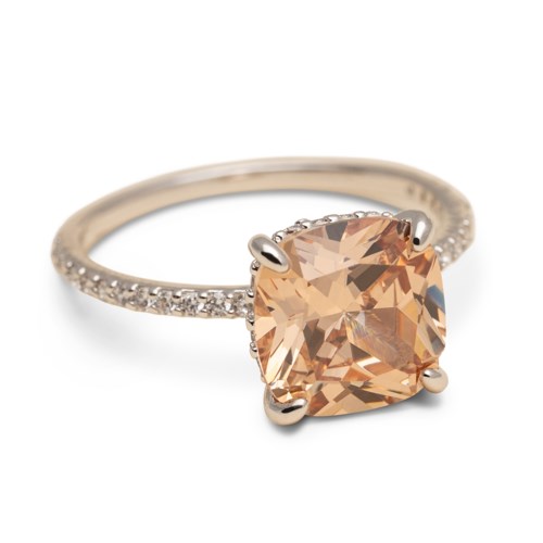 En ring med stor ferskenfarvet sten og små diamanter på båndet.