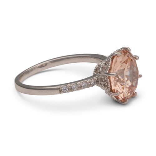Ein Silberring mit einem großen pfirsichfarbenen Stein und kleinen Diamanten am Band.
