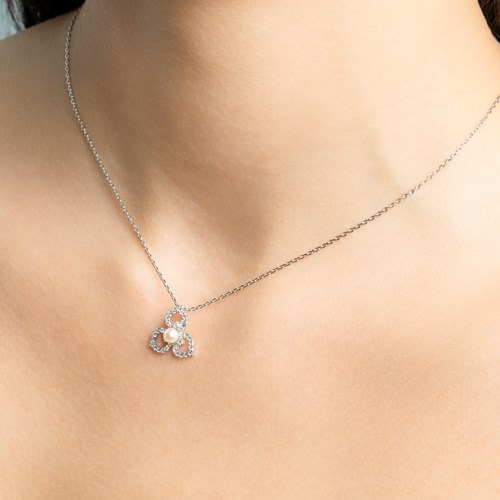 Ett tunt halsband med en fjärilsformad berlock med en pärla och små stenar.