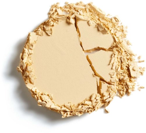 Brækket beige pudder med en ru, knust overflade og spredte stykker omkring.
