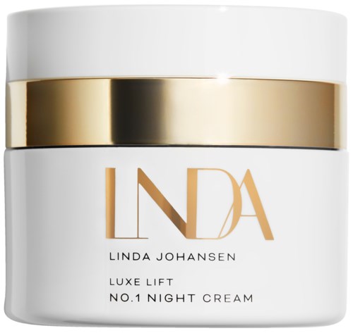 En hvit krukke med en gull- og svart stripe, merket 'Linda Johansen Luxe Lift No.1 Night Cream' inni.