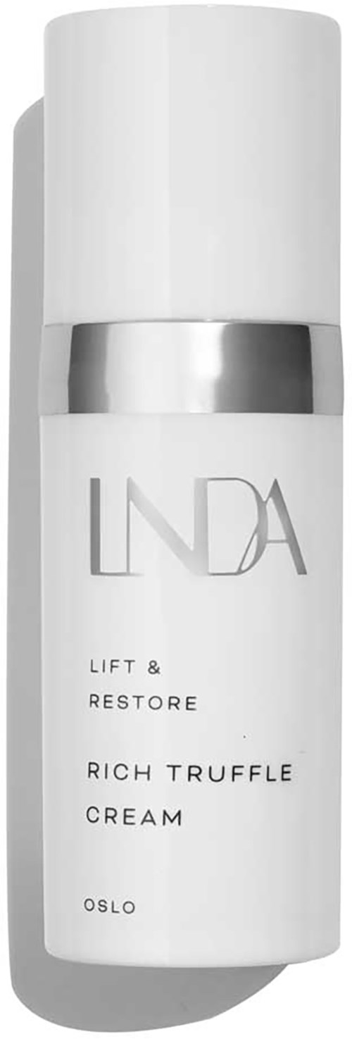 En hvit flaske med sølvbånd, merket 'LIND'A' for ansiktskrem, med ordene 'Lift & Restore' og 'Rich Truffle Cream'.