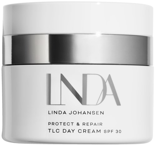 En hvit rund beholder med sølvbånd, merket 'LDA' og 'LINDA JOHANSEN', for hudkrem. Den nevner beskyttelse og reparasjon.
