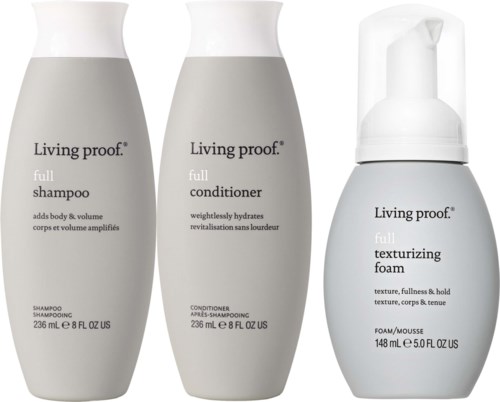 Three bottles: shampoo, conditioner, and texturizing foam from Living Proof, all in white bottles with black text.
