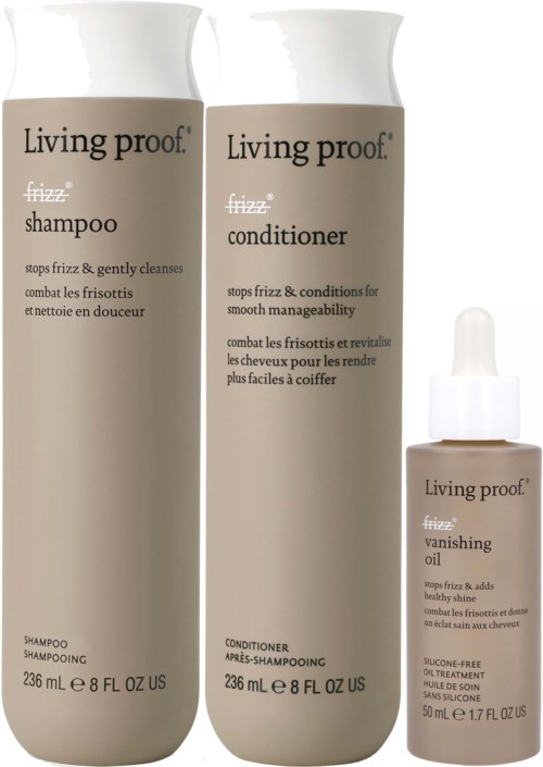 Three hair care products: shampoo, conditioner, and vanishing oil from Living proof. They are in bottles with white caps.