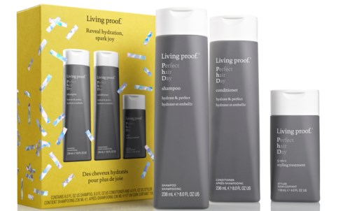 Et hårplejesæt med shampoo og balsam i sorte flasker, pakket i en gul boks med blå og sølv konfetti.