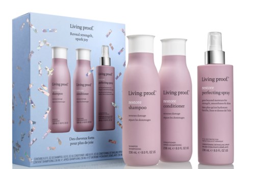 A hair care set with shampoo, conditioner, and spray in pink bottles, branded 'Living proof.' and a blue box.