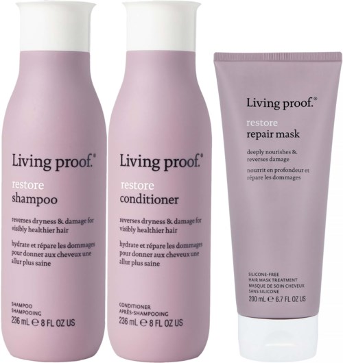 Three pink bottles: shampoo, conditioner, and repair mask from Living proof, designed for healthy hair care.