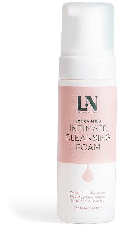 En rosa och vit flaska med intim rengöringsskum, märkt 'extra mild'. Den är parfymfri och dermatologiskt testad.